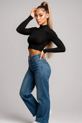 Trendy black long sleeve crop top for women paired with high-waist jeans